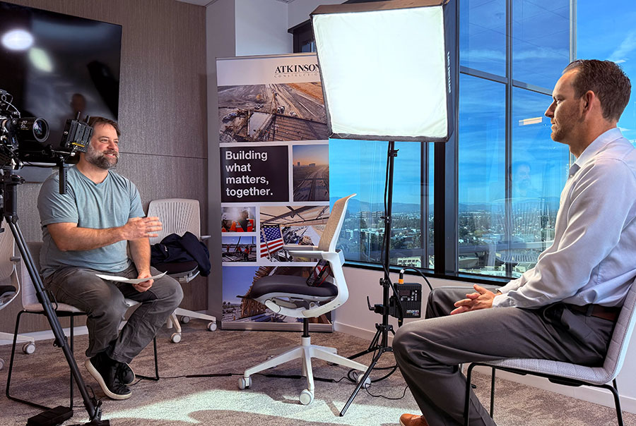 Video producer interviews subject during video shoot in conference room