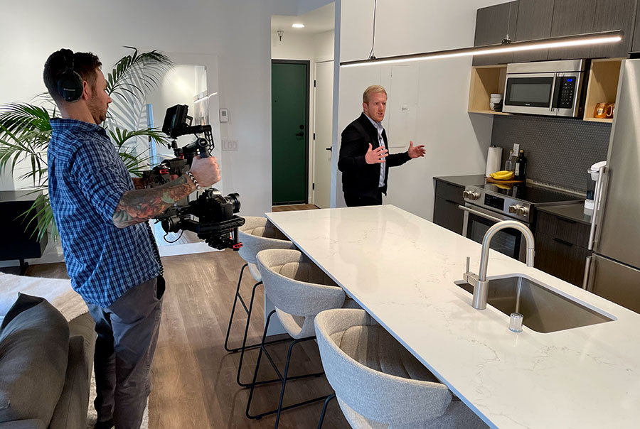 Videographer shoots walkthrough video tour with real estate professional